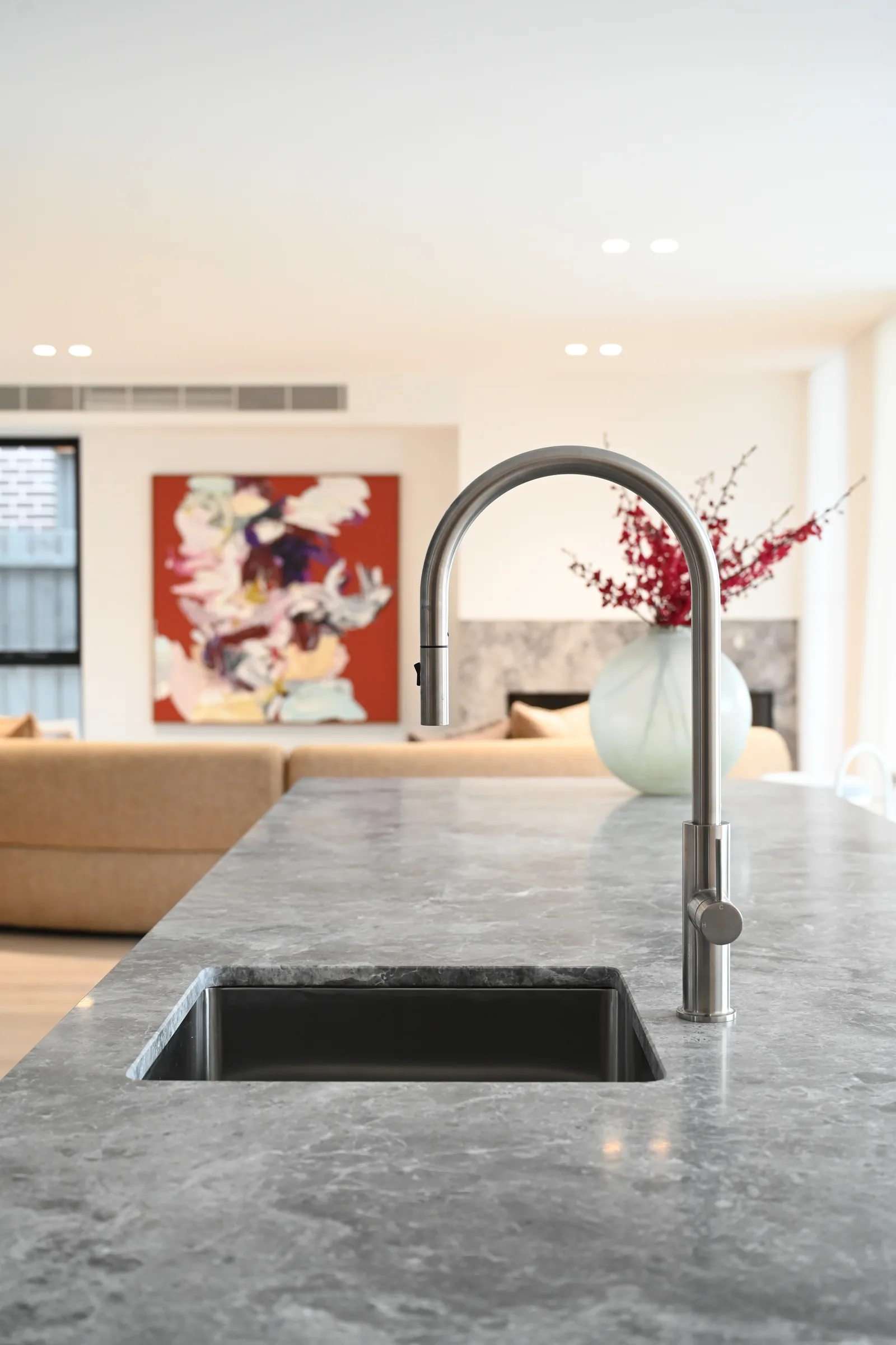 Close detail of veined grey marble and light oak joinery at Noga Avenue