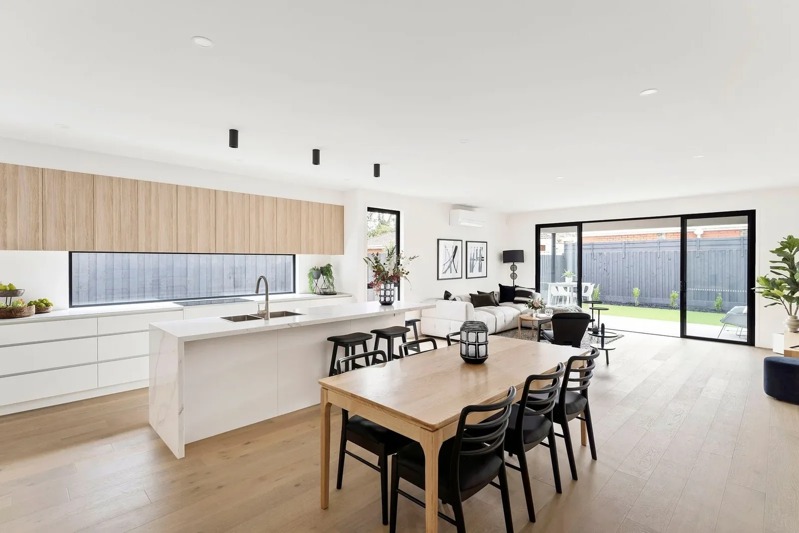 Long stone kitchen island and oak cabinetry at Nyah Street